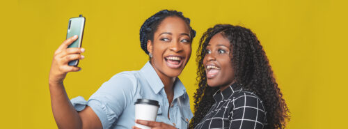 Two black women smiling taking a selfie